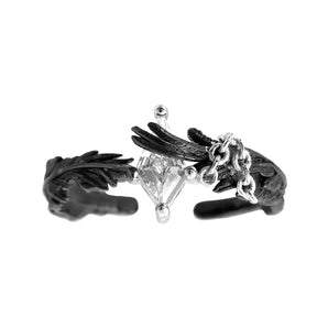 A Part Of Me dove and crow ring with black feather details and a clear center stone, front view