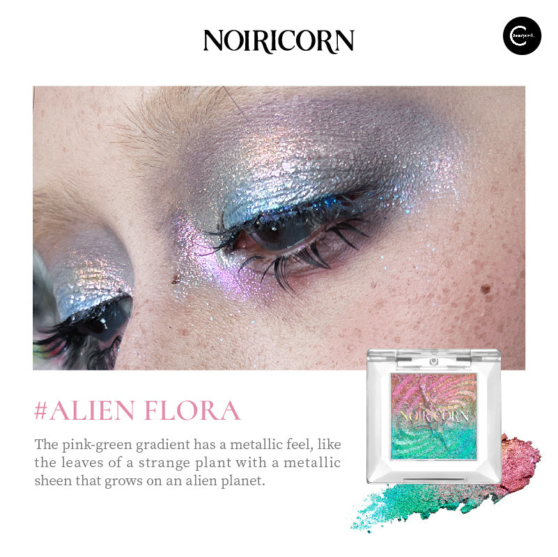 NOIRICORN Alien Flora single eyeshadow compact with pink-green shimmer swatch and eye makeup close-up