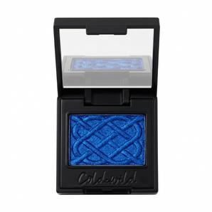 Open compact with vivid blue pressed powder, an embossed geometric pattern, and a mirror reflecting the pan.