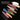 Multicolor makeup powder swatches in matte, shimmer, metallic and glitter finishes on a black background