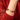Gugong Wenbao red-bead bracelet with a pale green centerpiece, shown on a wrist